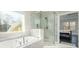 Luxurious Primary bath with separate tub and shower, and marble tile at 1560 Tapestry Rdg, Lawrenceville, GA 30045