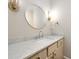 Bathroom with marble countertop, round mirror, and modern fixtures at 1560 Tapestry Rdg, Lawrenceville, GA 30045