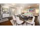 Dining room with hardwood floors, a black marble table, white chairs, and a view into the living area at 1560 Tapestry Rdg, Lawrenceville, GA 30045