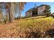 Rear exterior view of the home from the sloping, wooded backyard at 1560 Tapestry Rdg, Lawrenceville, GA 30045