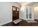 Home foyer with dark wood double doors, French doors, and dark wood floors at 1560 Tapestry Rdg, Lawrenceville, GA 30045