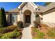 Front entry with stone arch, dark wood double doors, and landscaping at 1560 Tapestry Rdg, Lawrenceville, GA 30045