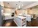 Modern white kitchen featuring an island, stainless steel appliances, and hardwood flooring, open to the living area at 1560 Tapestry Rdg, Lawrenceville, GA 30045