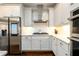 Modern white kitchen with stainless steel appliances, white countertops, and a stainless steel range hood at 1560 Tapestry Rdg, Lawrenceville, GA 30045