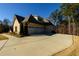 Three-car garage with a paved driveway and landscaped yard at 1560 Tapestry Rdg, Lawrenceville, GA 30045