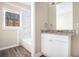 Updated bathroom with granite countertop, white cabinets, and marble shower at 2496 Montezuma Cir, Ellenwood, GA 30294