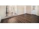 Bright dining room with dark wood-look floors and view into kitchen at 2496 Montezuma Cir, Ellenwood, GA 30294