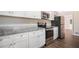 Modern kitchen featuring white cabinets, granite countertops and stainless steel appliances at 2496 Montezuma Cir, Ellenwood, GA 30294