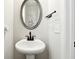 Small powder room with pedestal sink and oval mirror at 2141 Westside Dr, Austell, GA 30106