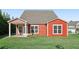 Red two-story home with covered back patio, green lawn, and trees at 100 Academy Ln, Canton, GA 30114