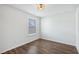 Empty bedroom with wood-look flooring, a single window, and a modern light fixture at 100 Academy Ln, Canton, GA 30114