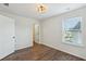 Empty bedroom with light walls, wood floors, and a doorway leading to another room at 100 Academy Ln, Canton, GA 30114