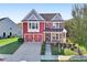A charming two-story red home with a front porch and attached garage at 100 Academy Ln, Canton, GA 30114