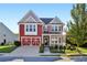 Charming two-story red home with a welcoming front porch and attached garage at 100 Academy Ln, Canton, GA 30114