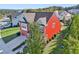 Red two-story home with a driveway, landscaping, and trees at 100 Academy Ln, Canton, GA 30114
