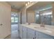 Double vanity bathroom with a large mirror and adjacent bedroom view at 565 Teversham Dr, Mcdonough, GA 30253