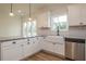 Bright kitchen featuring white cabinets, granite countertops, and a farmhouse sink at 1452 Alcovy Station Rd, Covington, GA 30014