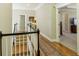 Upstairs hallway with hardwood floors, neutral walls and a view of bedrooms at 610 Americas Cup Cv, Alpharetta, GA 30005