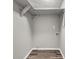 Laundry area with gray walls, wood-look floors, and overhead shelving at 1396 Iron Gate Blvd, Jonesboro, GA 30238