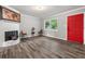Bright living room with red door, wood-look floors, and a fireplace at 1396 Iron Gate Blvd, Jonesboro, GA 30238