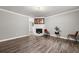 Living room with gray walls, wood-look floors, and a white brick fireplace at 1396 Iron Gate Blvd, Jonesboro, GA 30238
