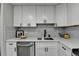 Modern white kitchen with stainless steel appliances and marble countertops at 1920 Suwanee Valley Rd, Lawrenceville, GA 30043