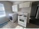 Compact kitchen featuring white appliances, ample cabinetry, and modern flooring at 2259 Whites Mill Rd, Decatur, GA 30032