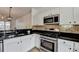 Modern kitchen with stainless steel appliances, dark countertops, and white cabinets at 317 Devonshire Dr, Alpharetta, GA 30022