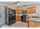 Modern kitchen with black appliances and wood cabinets at 714 Carlton Pointe Way, Palmetto, GA 30268