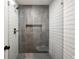 Sleek shower with gray and white tile, glass enclosure, and built-in shelf at 4619 Brunning Ct, Dunwoody, GA 30338