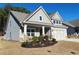 Two-story house with gray siding, stone accents, and a three-car garage at 590 Plainfield St, Fayetteville, GA 30215