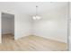 Empty dining room with light wood-look floors, white walls, and a simple chandelier at 906 Country Park Se Dr, Smyrna, GA 30080