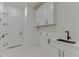 Laundry room with white cabinets, quartz countertops, and a farmhouse sink at 522 Hope Hollow Ln, Loganville, GA 30052