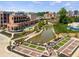 Aerial view of a community with a pond, walking paths, and modern buildings at 1187 Chastain Dr # 56, Sugar Hill, GA 30518