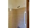 Shower with neutral tile surround and grab bar at 2027 Kensington High St, Lilburn, GA 30047