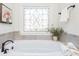 Relaxing bathroom featuring a soaking tub and a stained-glass window at 404 Monarch Lake Dr, Canton, GA 30115