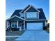 Two-story home with gray siding, white garage door, and landscaping at 2349 Hanover Woods Rd, Lithonia, GA 30058