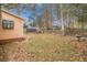 Large backyard with trees, fallen leaves, and a wooden fence at 10359 Briarbay Loop, Jonesboro, GA 30238