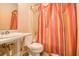 Simple bathroom with a colorful shower curtain and a pedestal sink at 10359 Briarbay Loop, Jonesboro, GA 30238