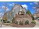 Side view of two-story home with decorative brick wall and landscaping at 212 Mcaffee St, Woodstock, GA 30188