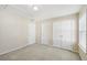 Bright bedroom with neutral walls, carpet, and double doors to closet at 589 Lantern Wood Dr, Scottdale, GA 30079