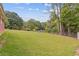 Spacious, fenced backyard with lush green grass and mature trees at 527 Main St, Suwanee, GA 30024