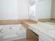 Bathroom boasts a large bathtub and vanity with a mirror at 608 Woodknoll Ct, Jonesboro, GA 30238