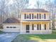 Two-story house featuring a beige exterior, brown roof, and a front porch at 608 Woodknoll Ct, Jonesboro, GA 30238