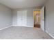 Well-lit bedroom featuring neutral carpeting and double door closet at 1215 Catalina Pkwy, Mcdonough, GA 30252