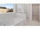 Bathroom with soaking tub, walk-in shower, and large window at 514 Nolden Trl, Dacula, GA 30019