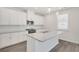 Modern kitchen with white cabinets, granite island, and stainless steel appliances at 514 Nolden Trl, Dacula, GA 30019