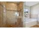 Modern bathroom with glass shower, soaking tub, and tiled walls at 185 Witheridge Dr, Johns Creek, GA 30097