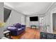 Living room features hardwood floors, a purple couch, and a large TV at 1324 Almont Sw Dr, Atlanta, GA 30310