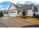 House exterior featuring a two-car garage and nicely landscaped yard at 304 Woodstock Seven Dr, Woodstock, GA 30188